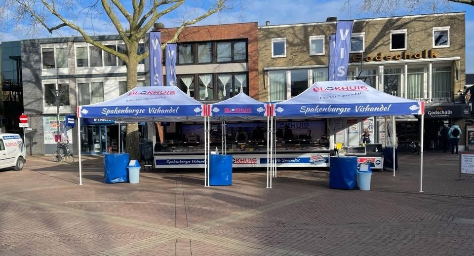 De blauwe marktkraam van Vishandel Blokhuis op een Nederlands marktplein